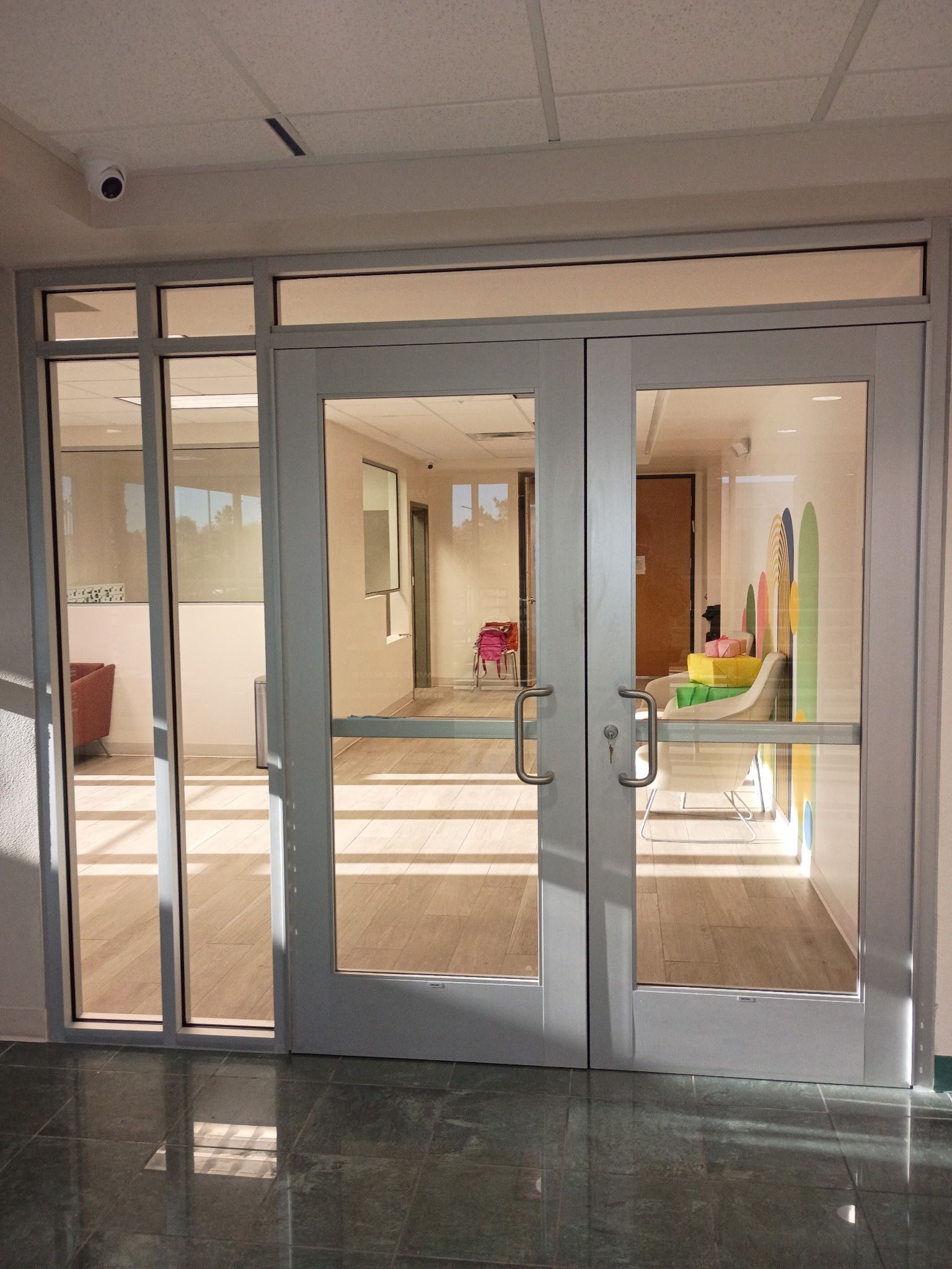 A hallway with a red carpet and a glass door