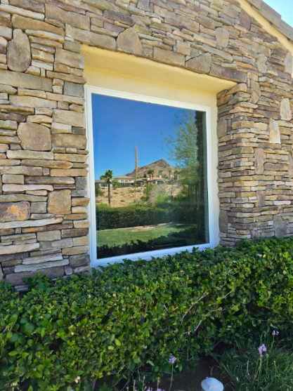 A large window on the side of a stone building.
