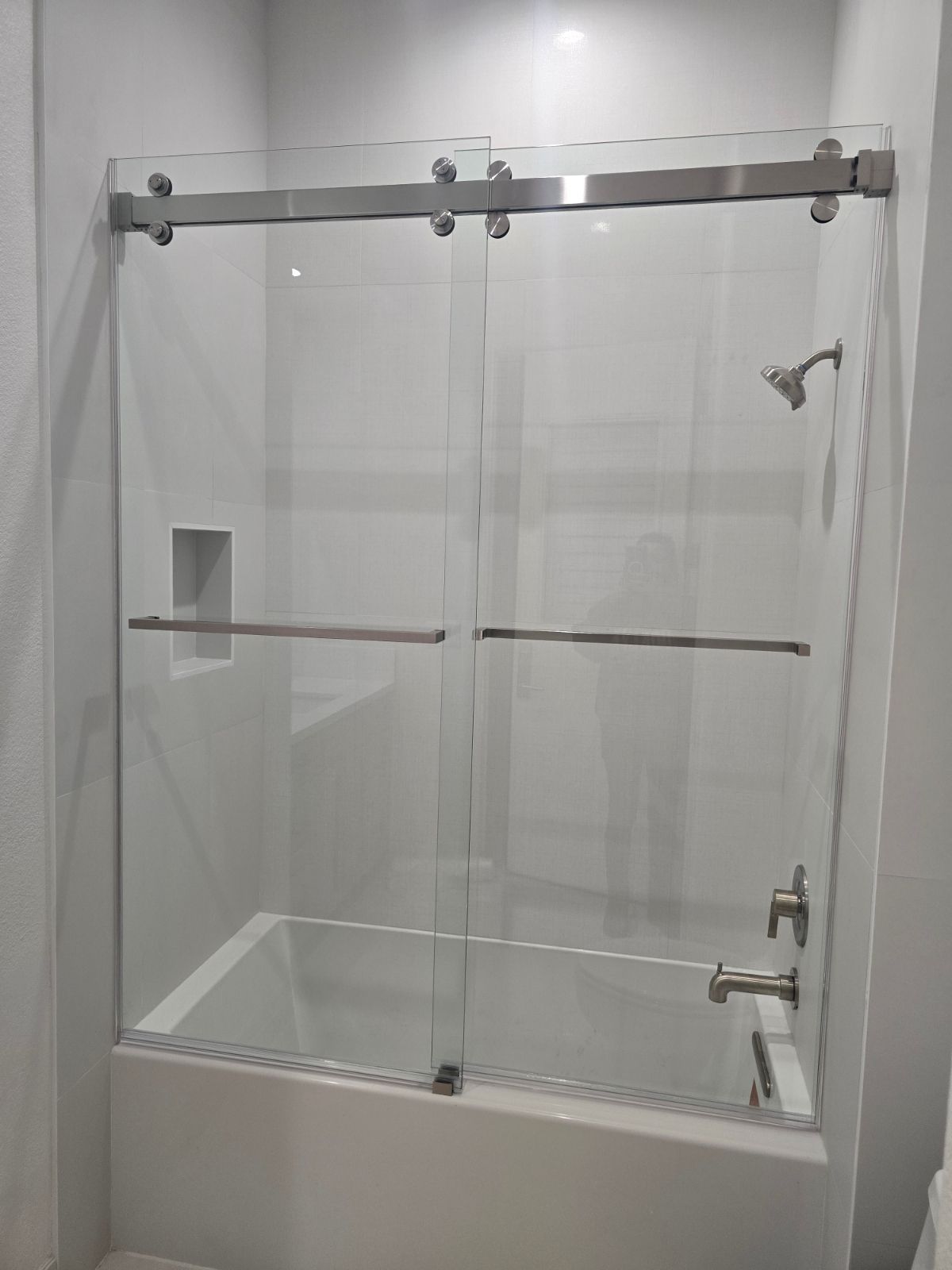 A bathroom with a sliding glass shower door and a bathtub.