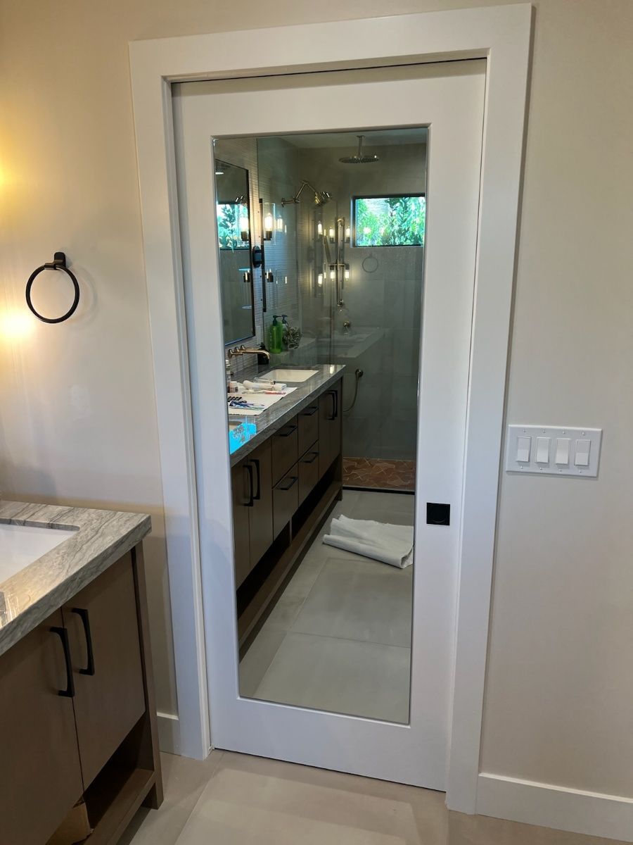 A bathroom with a mirror on the door and a sink.
