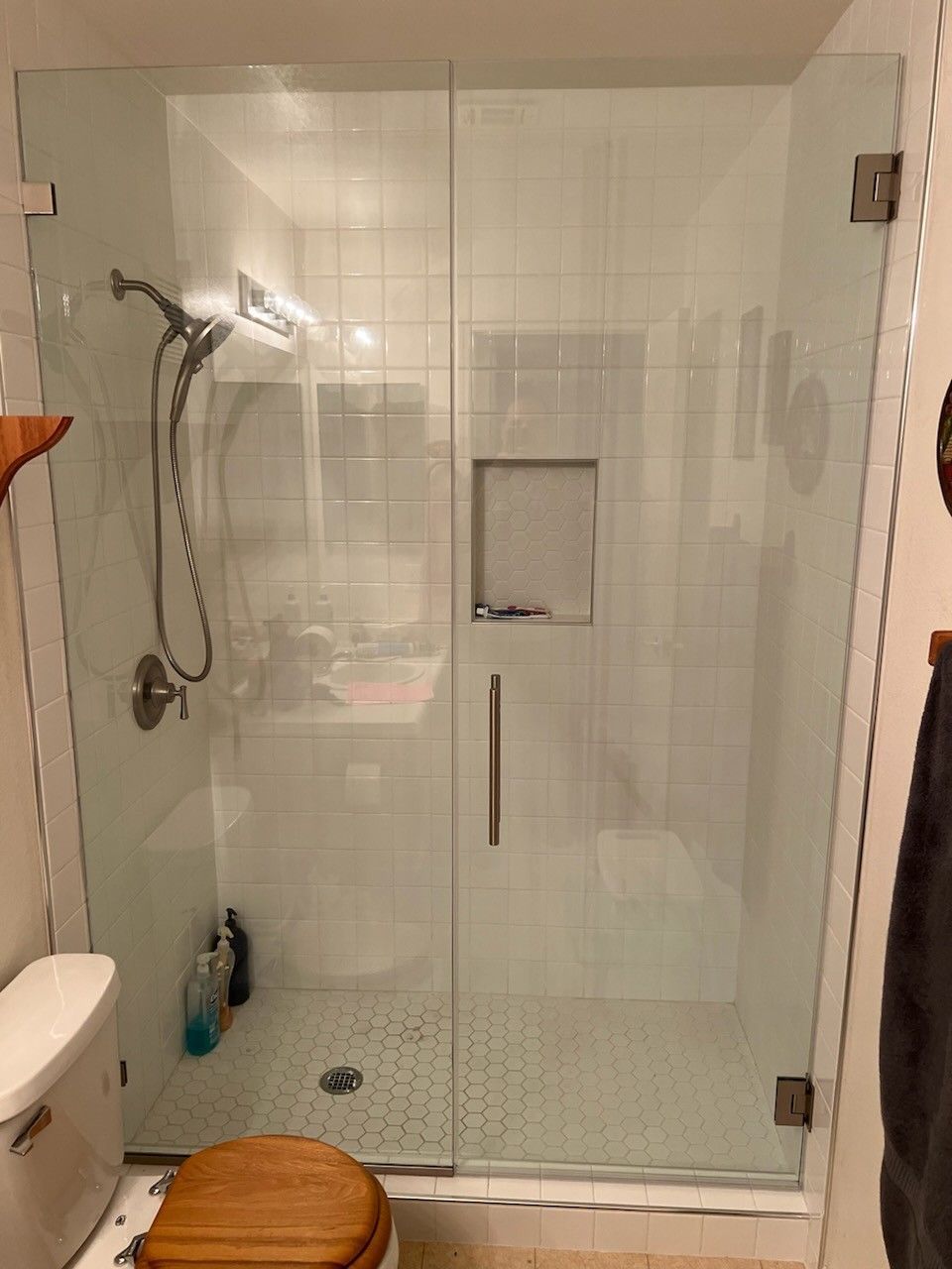 A bathroom with a glass shower door and a toilet.