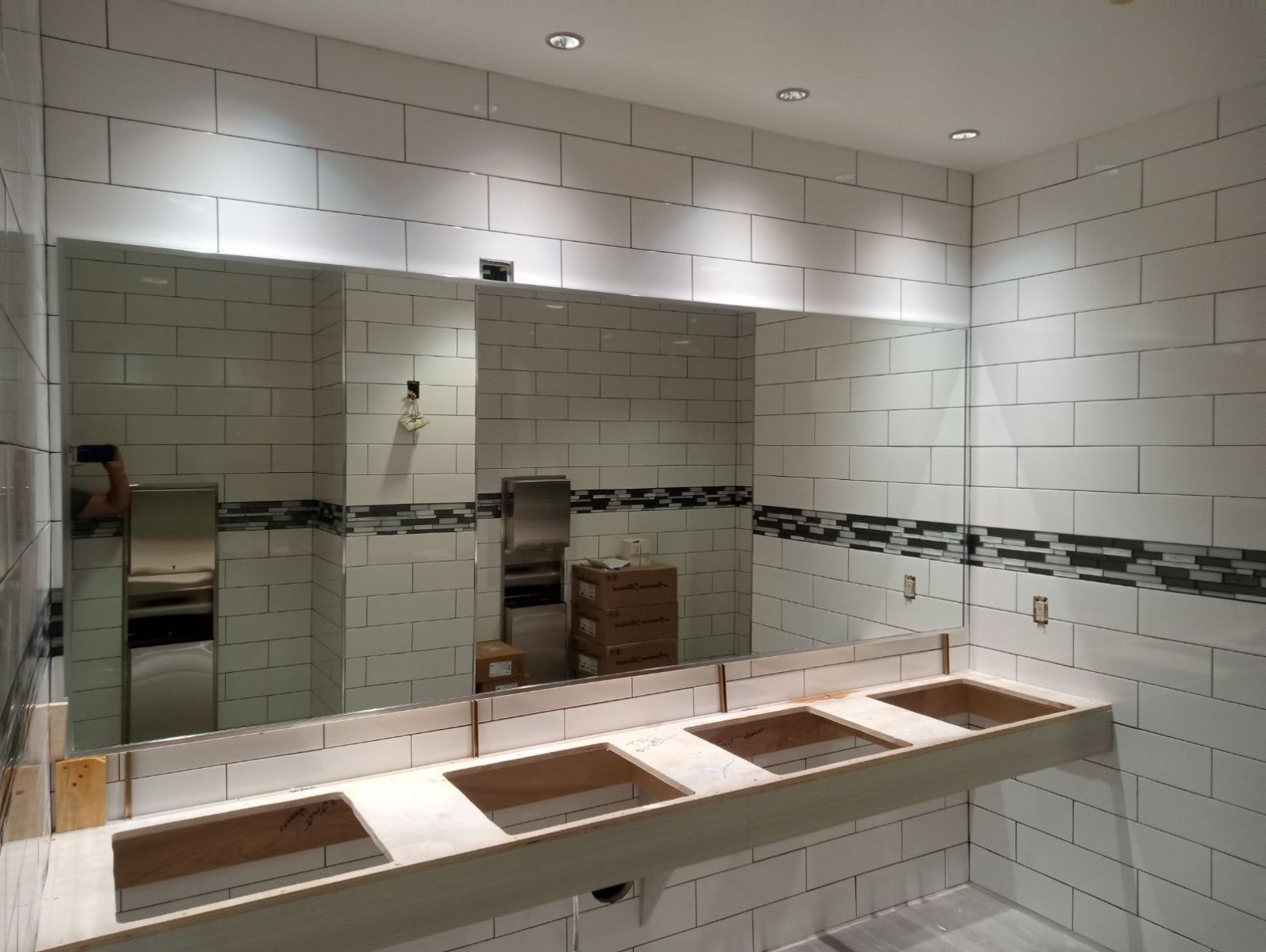 A bathroom with three sinks and a large mirror