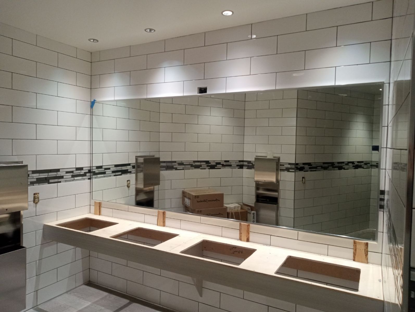 A bathroom with three sinks and a large mirror