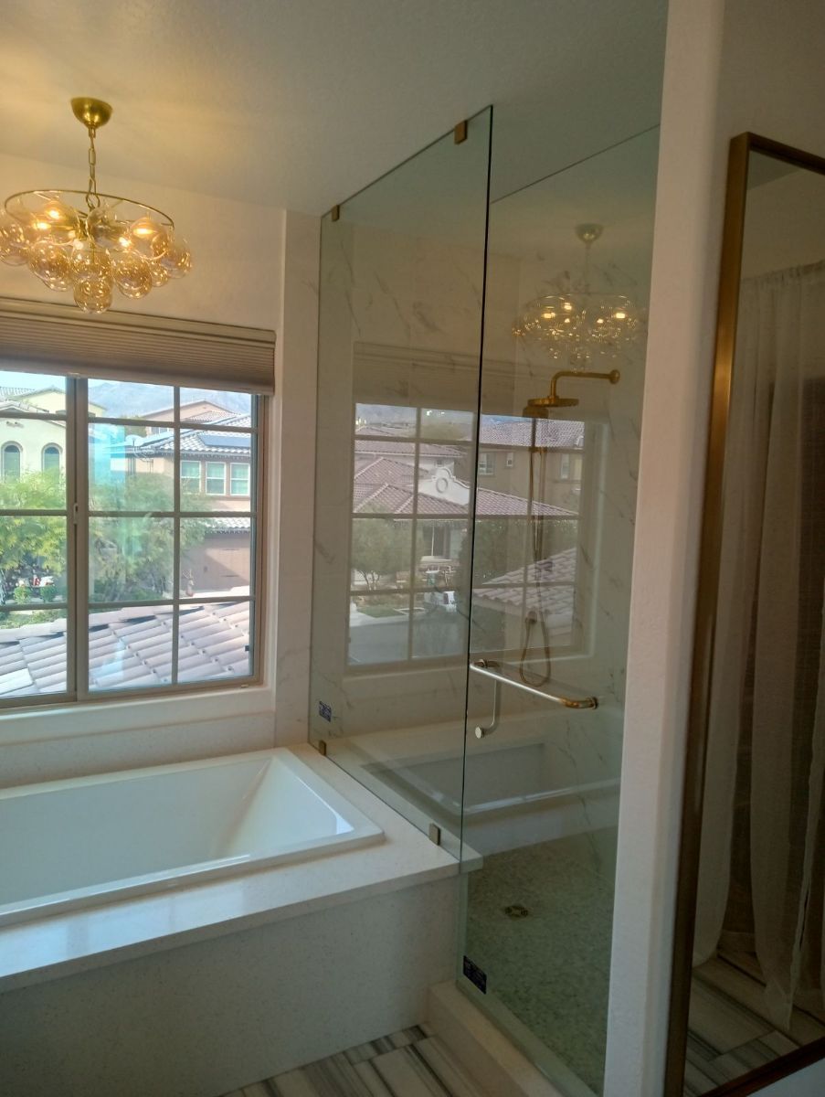 A bathroom with a tub a shower and a mirror