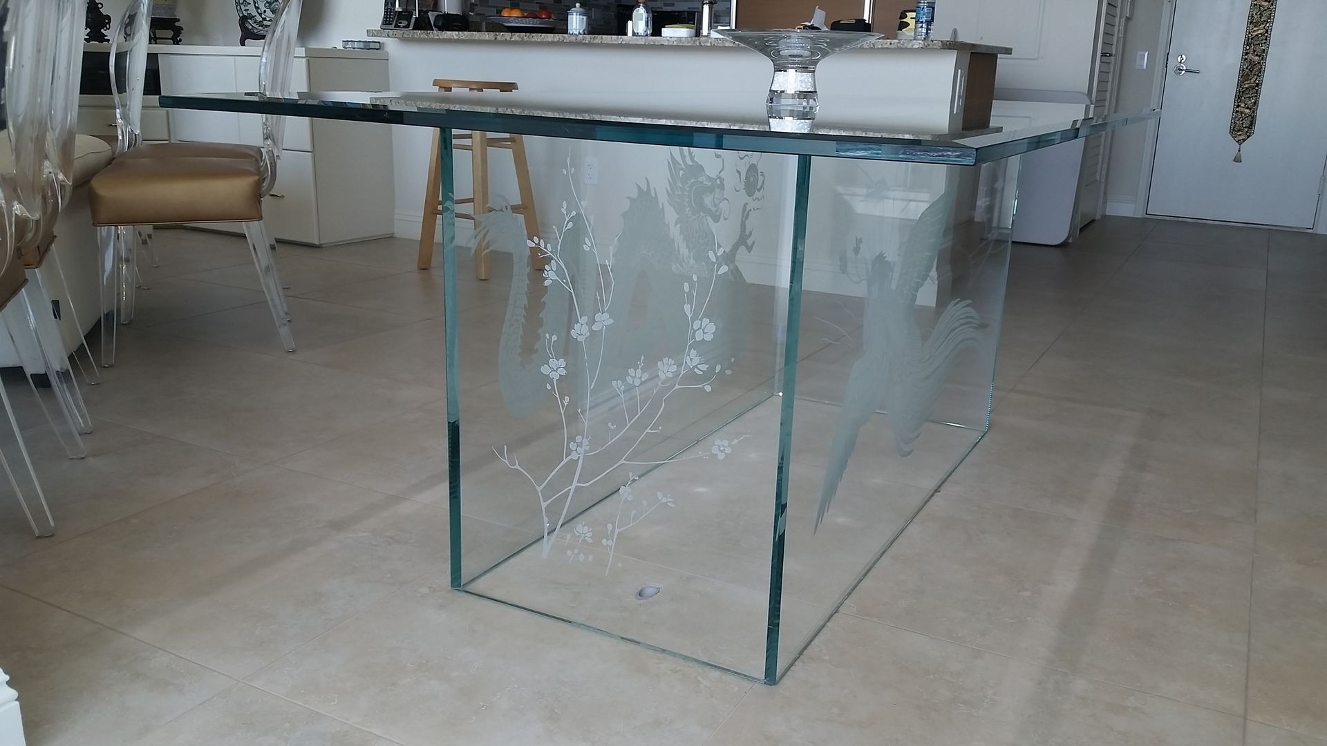 A glass table is sitting on a tiled floor in a living room.