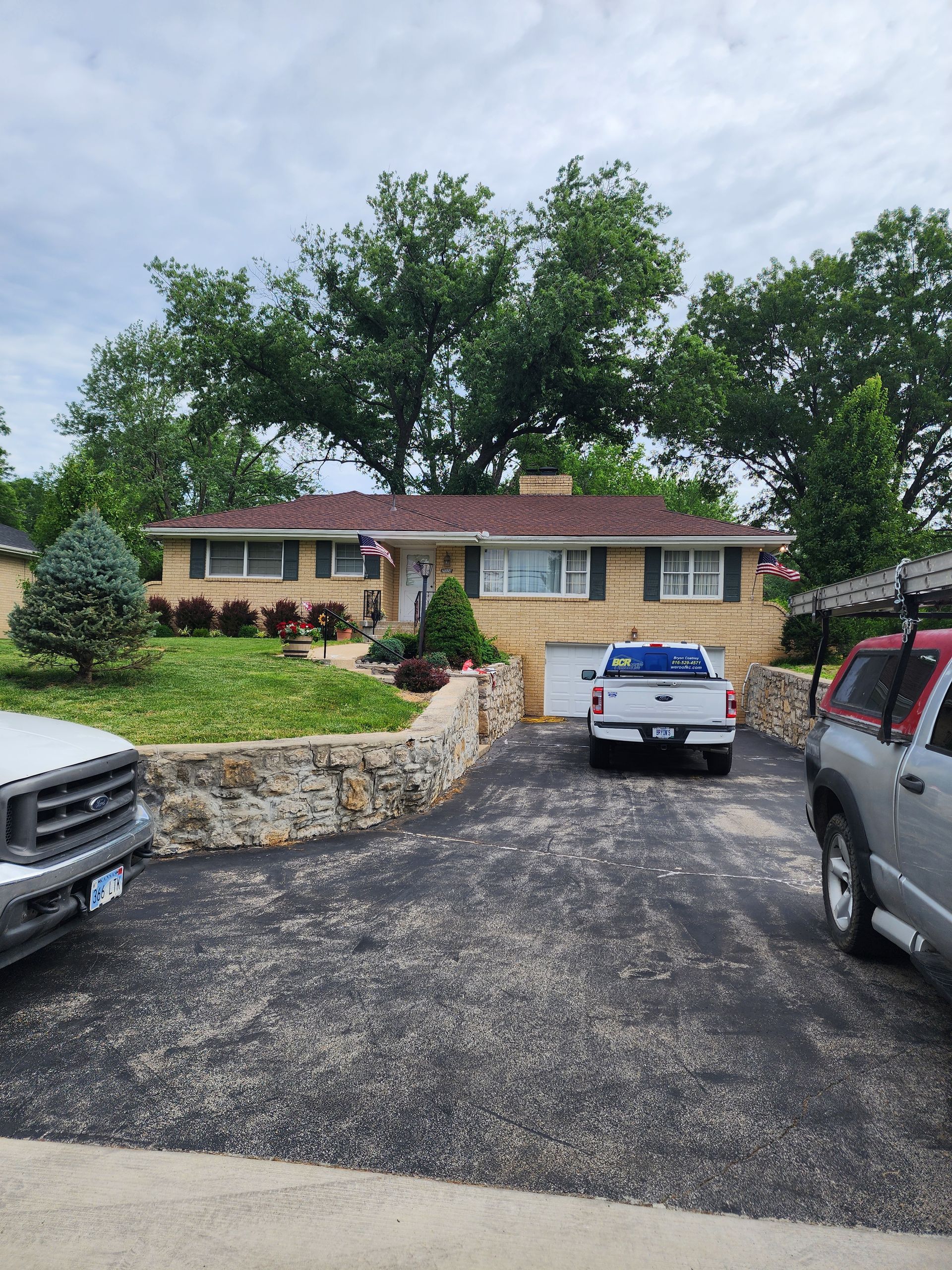 A couple of cars are parked in front of a house.