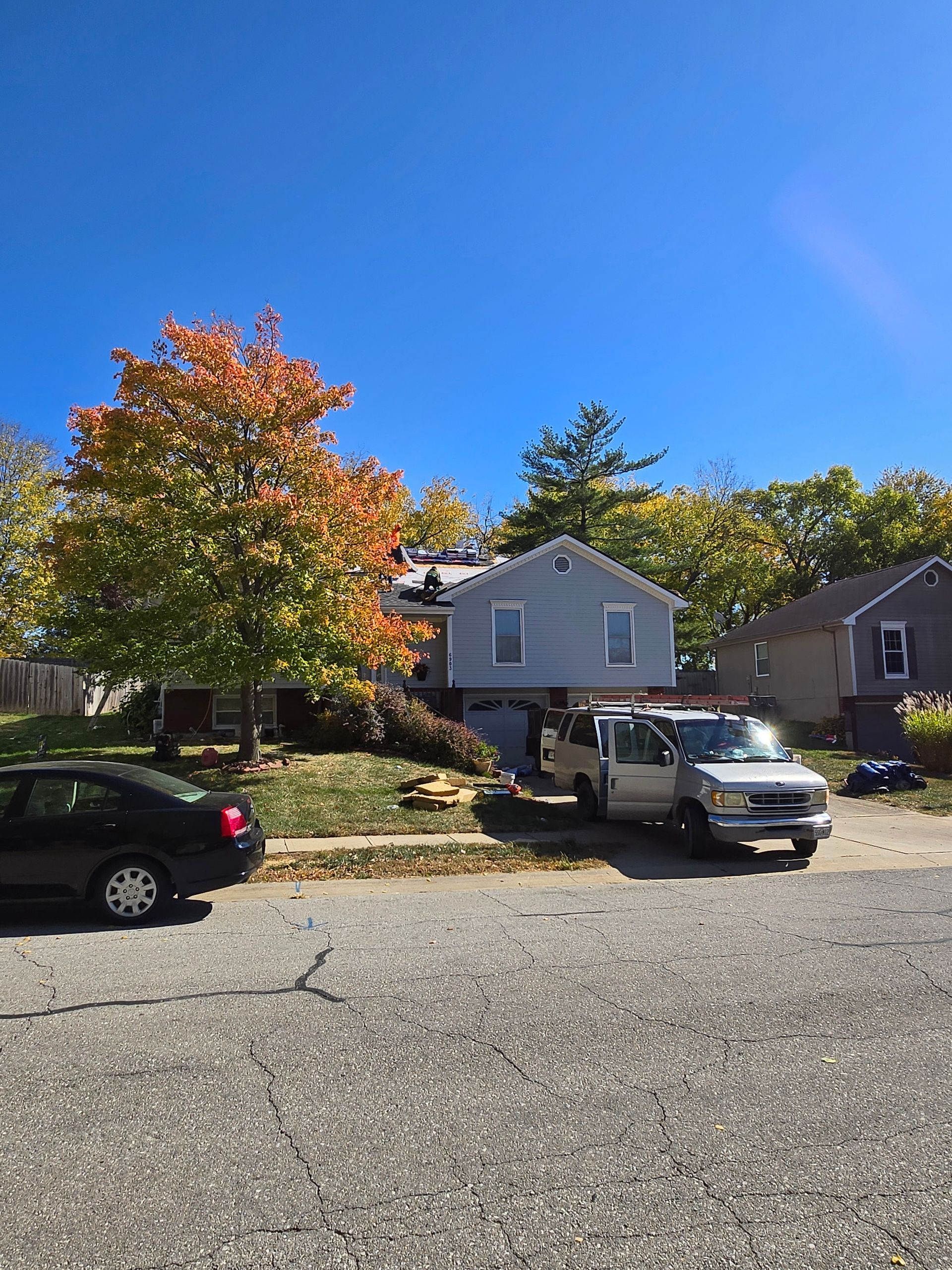 A white van is parked in front of a house.