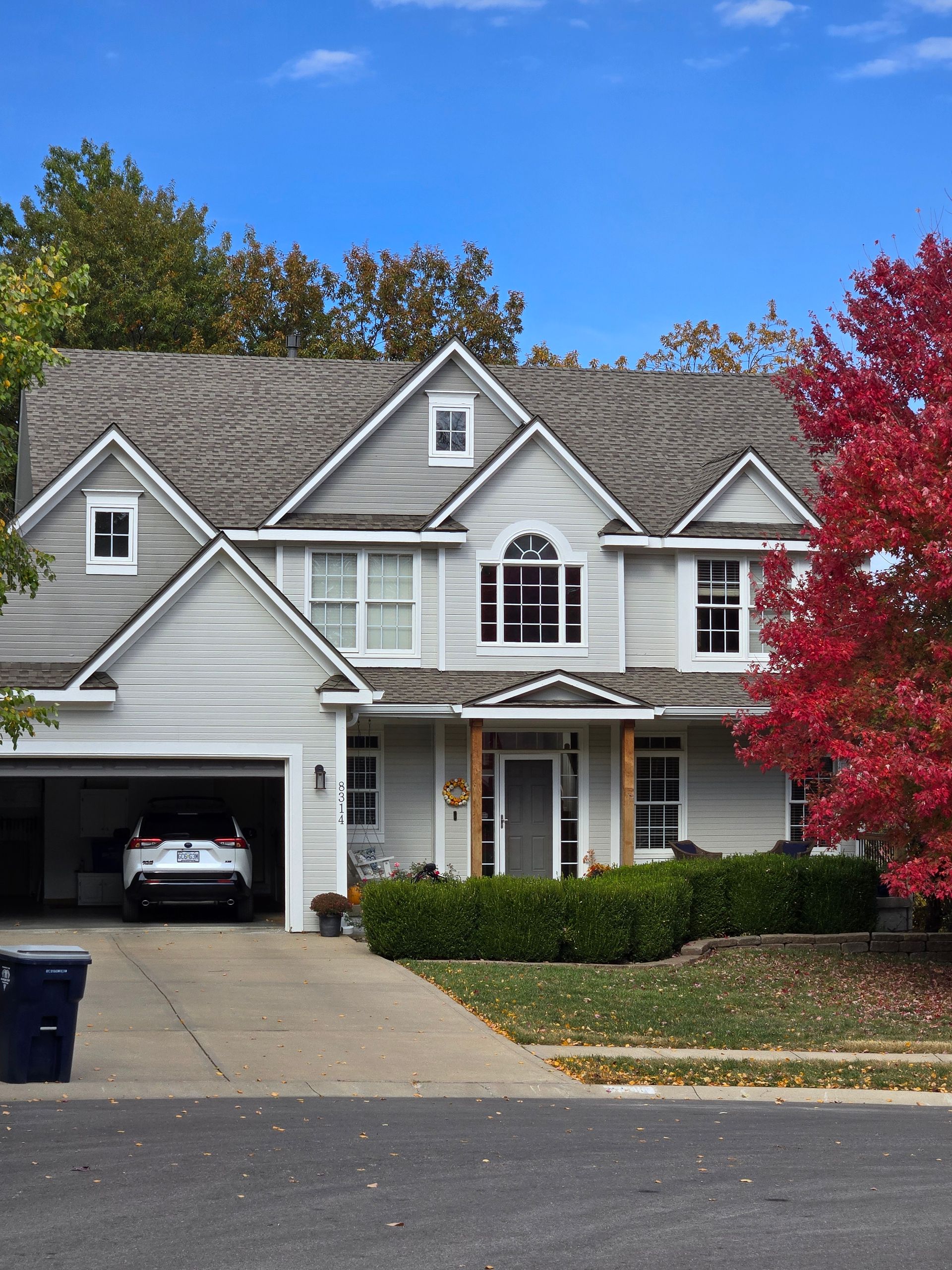 A white house with a car parked in the garage