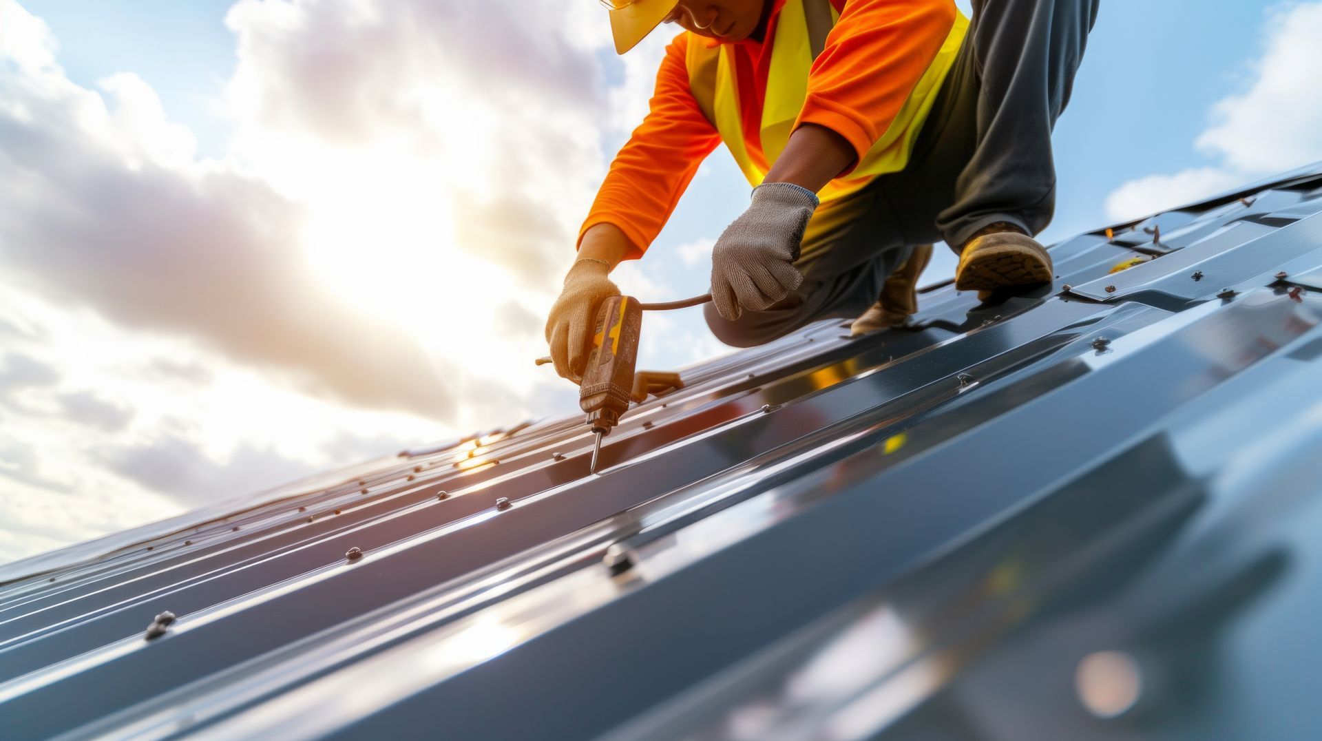 A construction worker is installing solar panels on a roof.