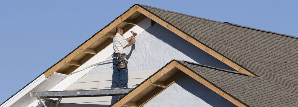 A man is working on the roof of a house.
