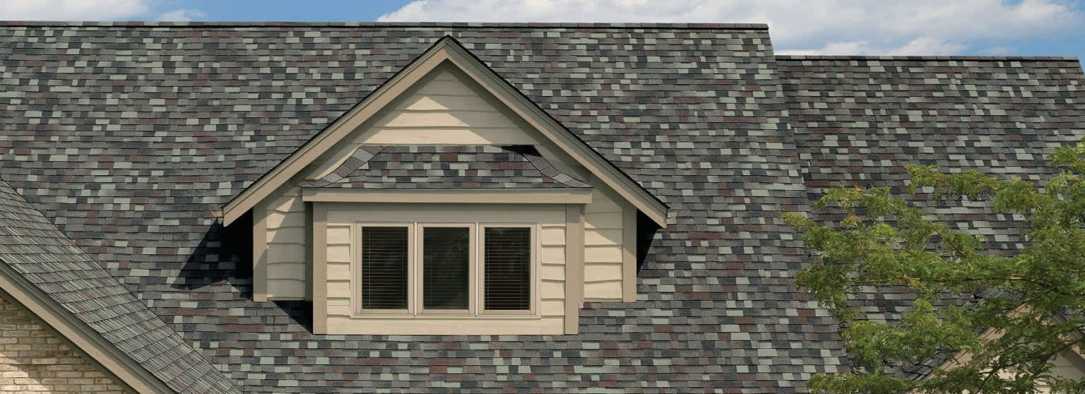 A house with a slate roof and a window on the roof.