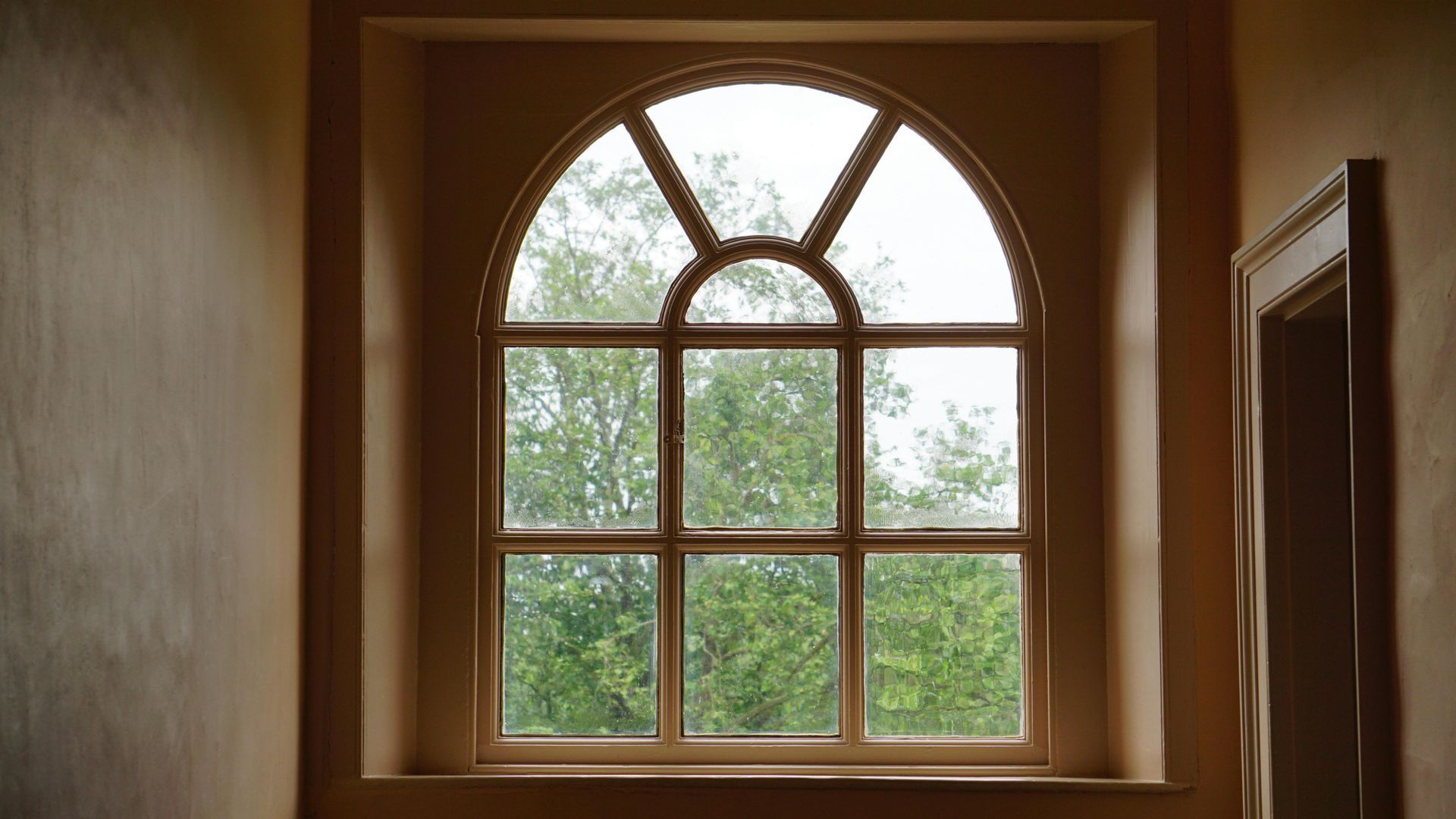 A man is installing a window on a house.