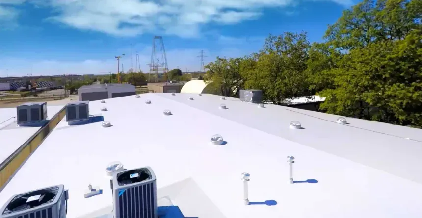 An aerial view of a white roof with air conditioners on it.
