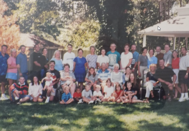 A large family posing for a picture in the grass