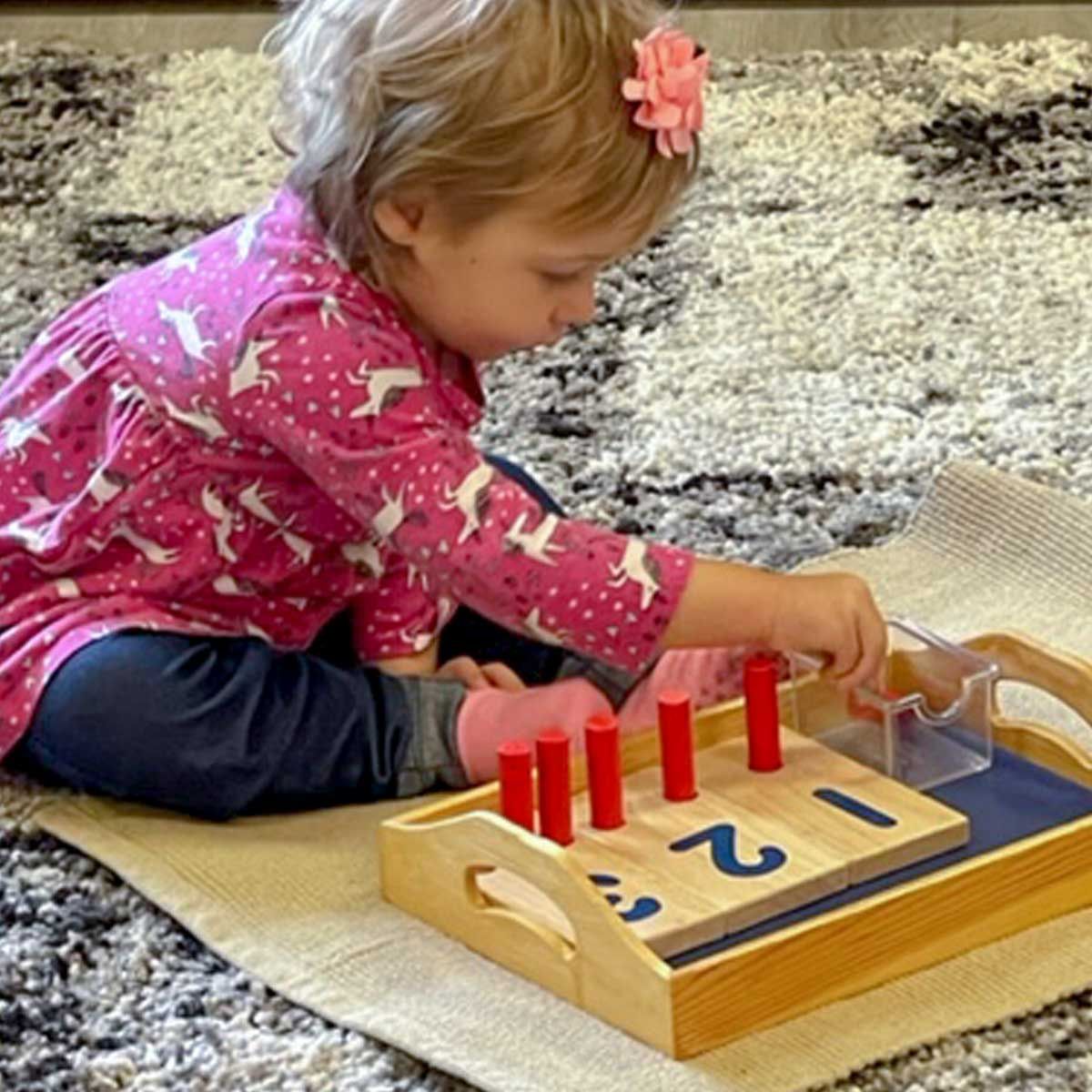 Montessori toddler playing with number tower material