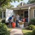 Two people loading items into a storage container at a house's entrance.