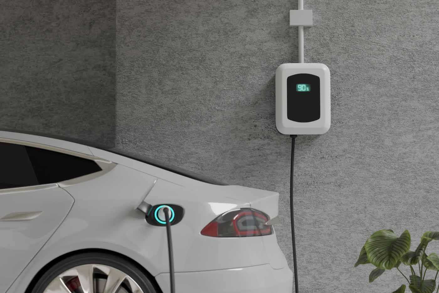 A white electric car is being charged in a garage.