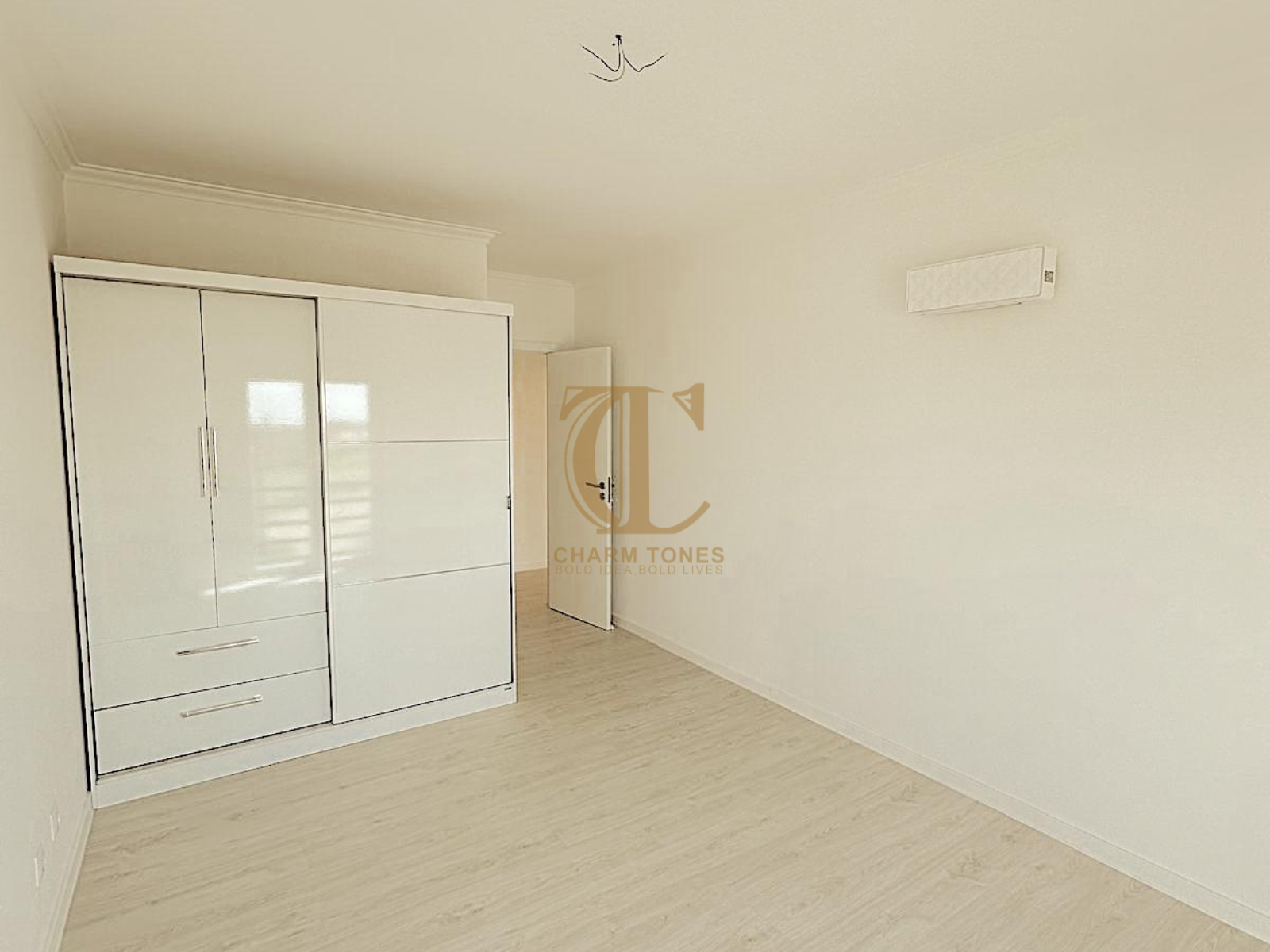 Um quarto com uma cama, cadeira, mesa de cabeceira e cômoda.