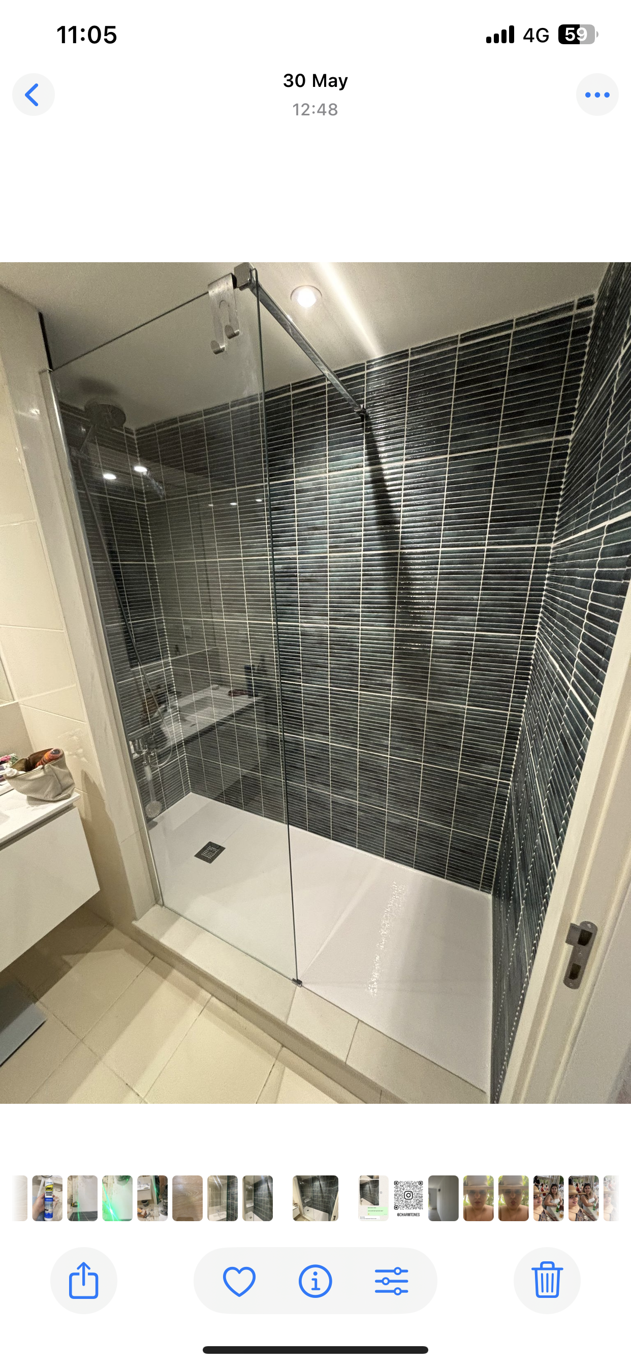 Um banheiro com chuveiro e parede de azulejos.