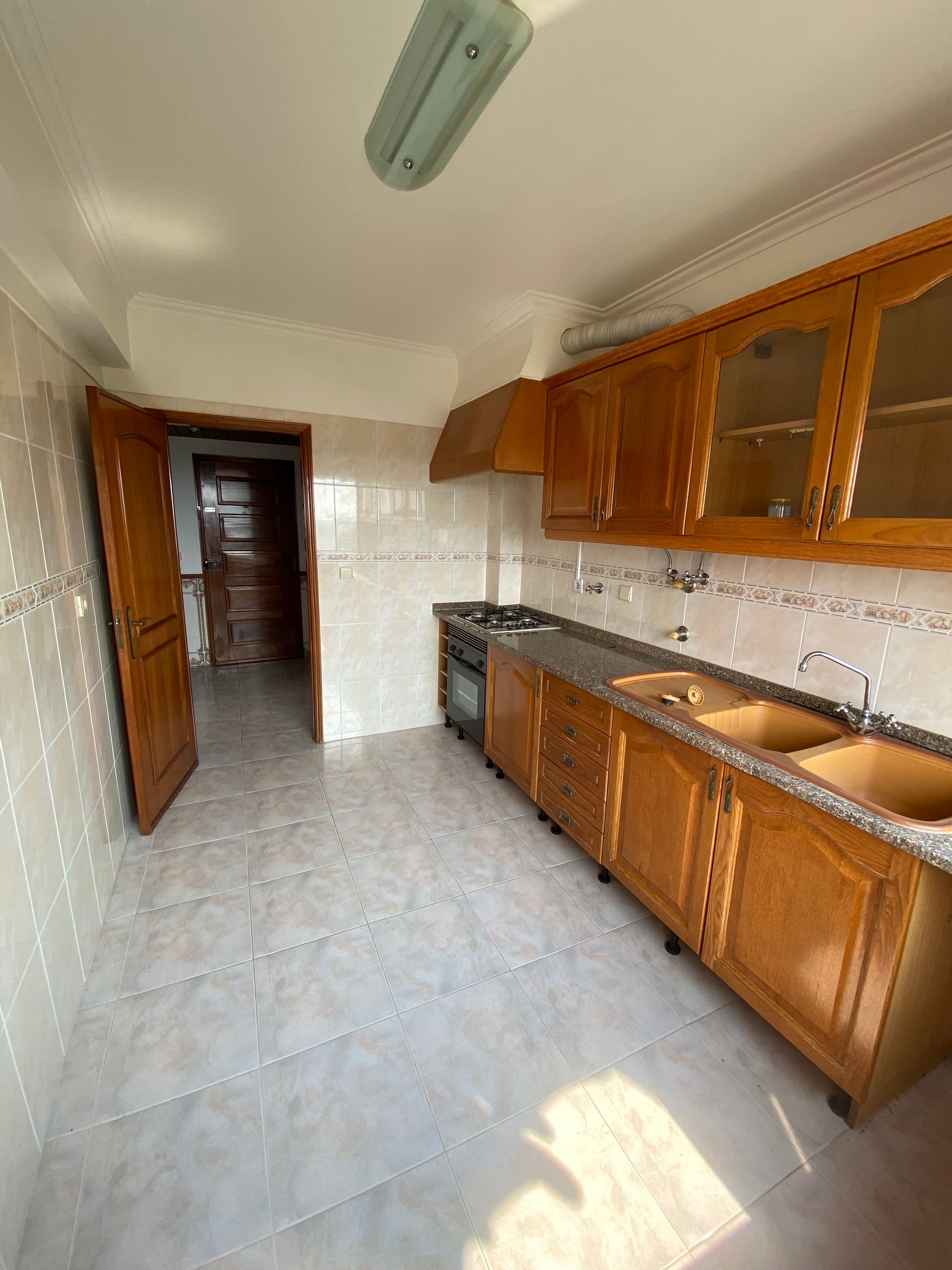 Uma cozinha com armários de madeira e bancadas de granito.