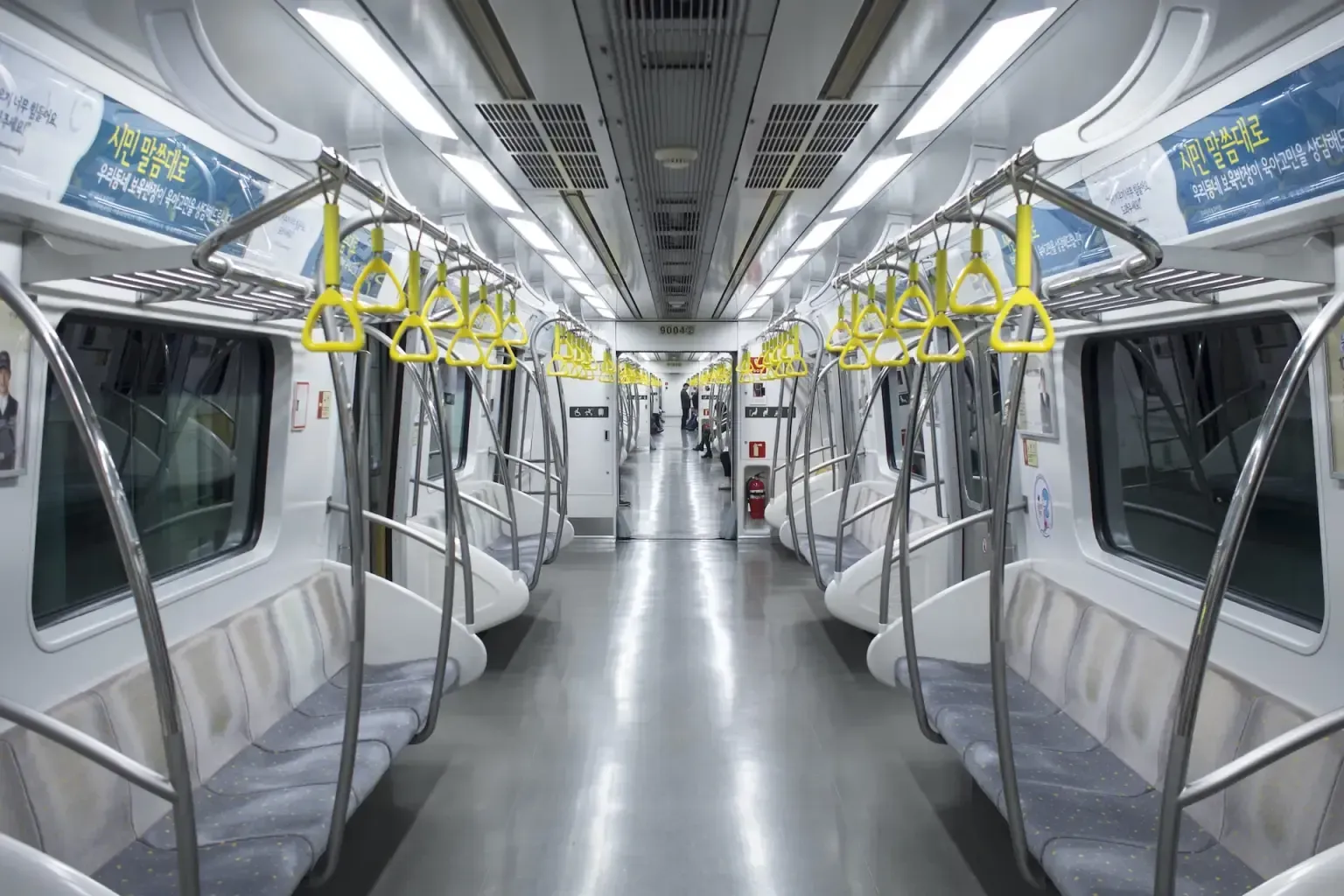 The inside of an empty subway car with a lot of seats.