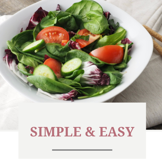 Salad in a white bowl with tomatoes, cucumbers, and greens;