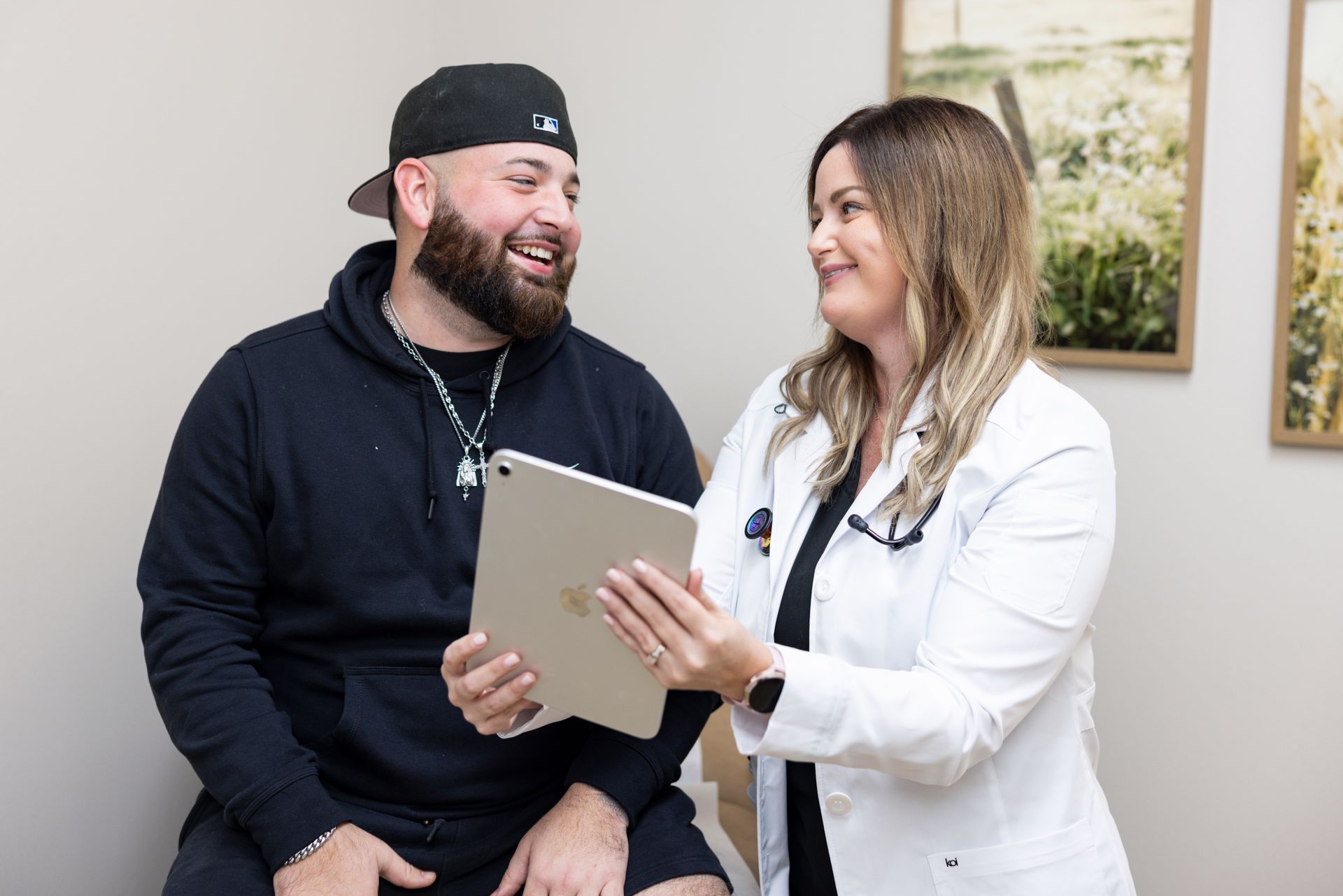 Doctor speaking with a child and parent in a hospital hallway. The doctor has his hand on the child's shoulder.