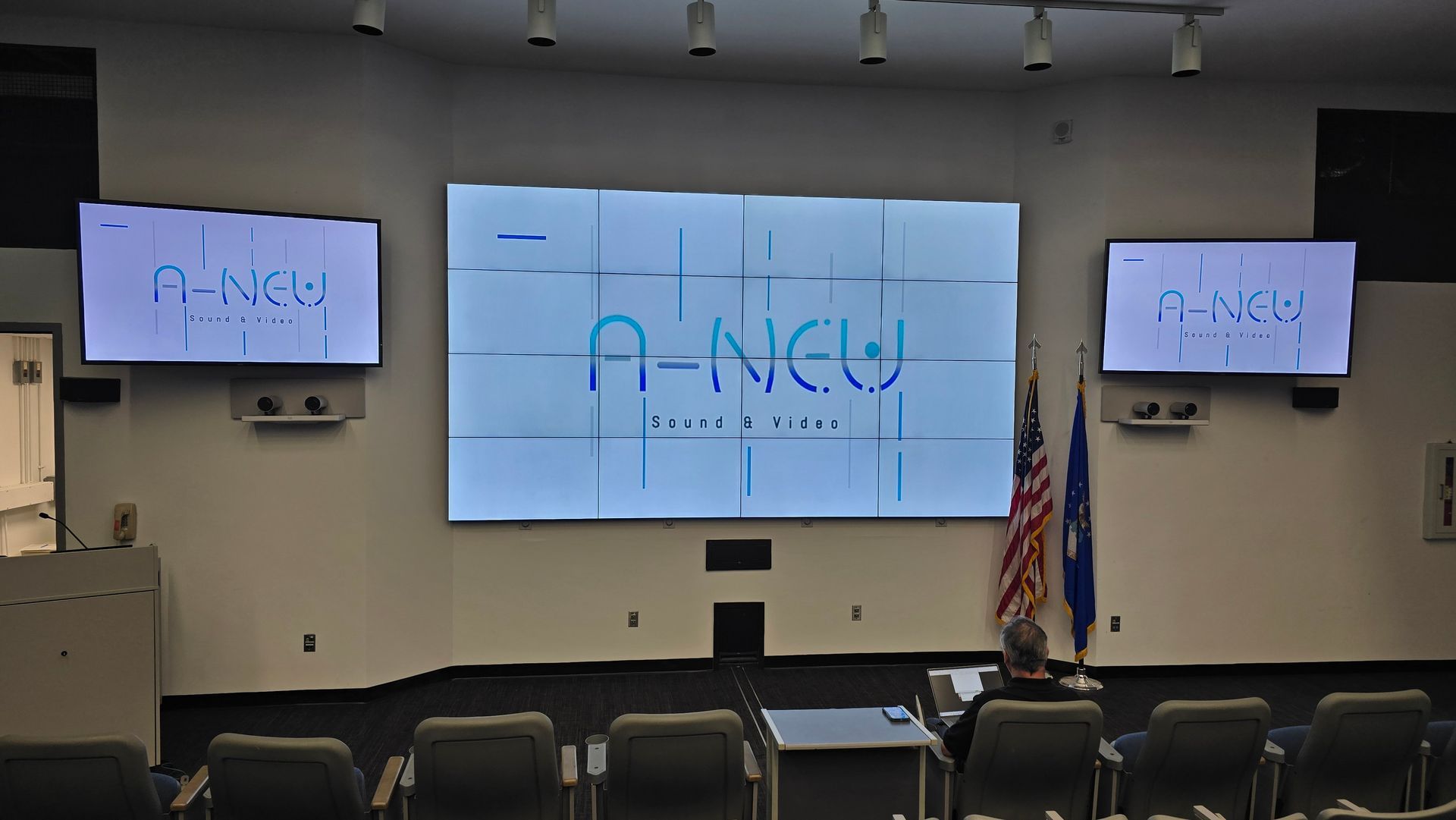 A presentation room with three screens displaying