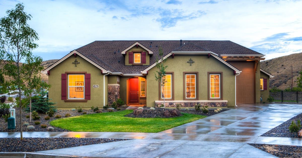 A large house with a garage and a sunset in the background.