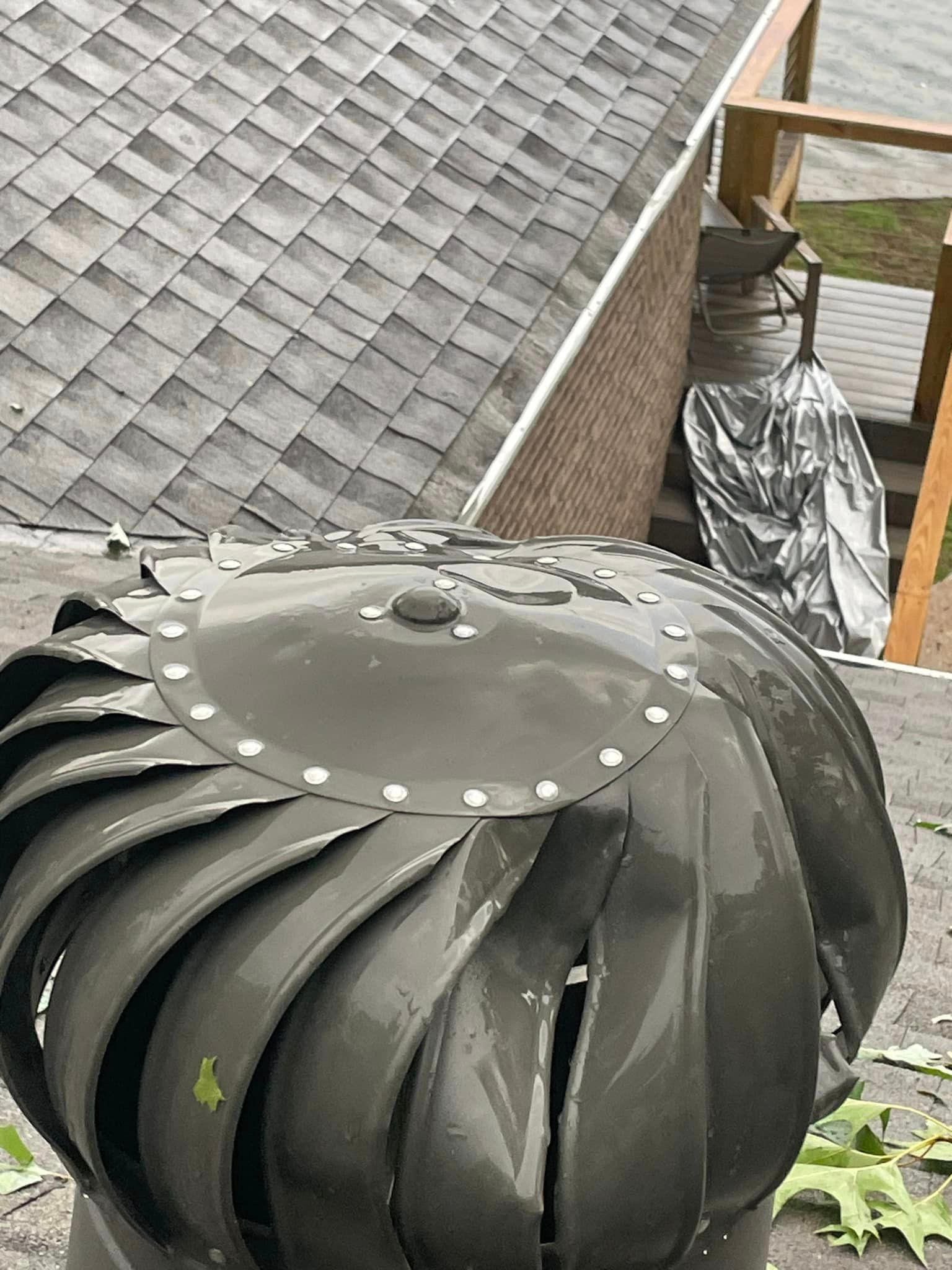 a wind turbine is sitting on top of a roof .