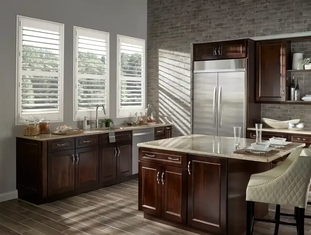 Dark wood kitchen with shutters, a large stainless steel refrigerator, and island.
