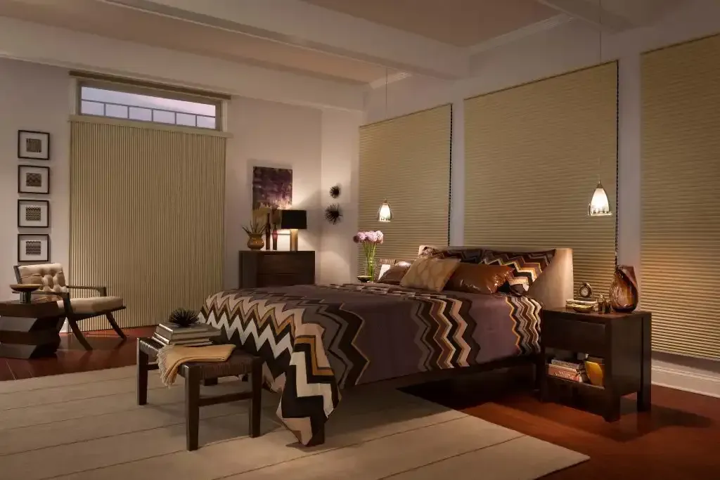 Bedroom with bed, nightstands, rug, chair, and large tan window coverings.