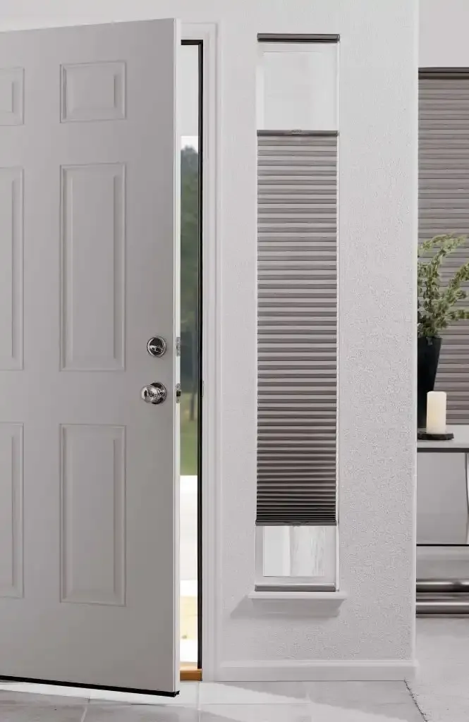 A white door open to a bright doorway, next to a window with gray blinds.