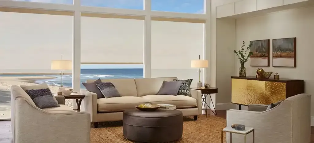 Living room with beige furniture, ocean view, and decorative gold cabinet.
