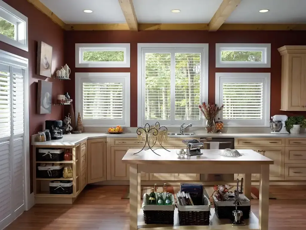 Kitchen with windows, wood cabinets, island, and red walls.