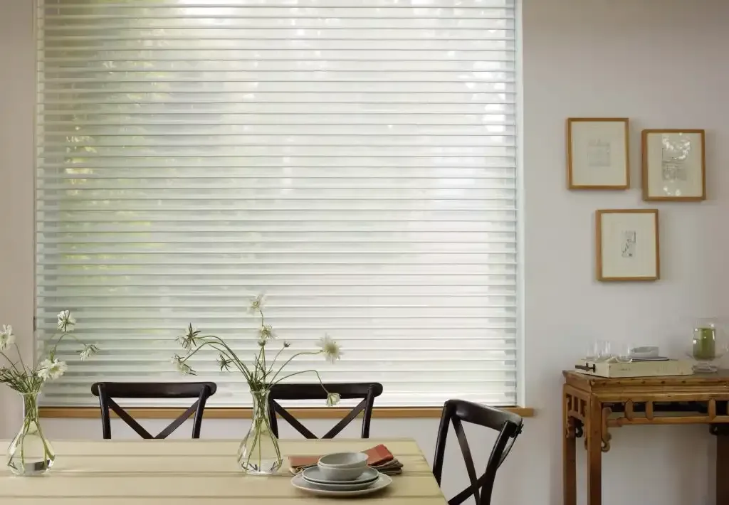 Dining room with a table set, window blinds, and framed art.