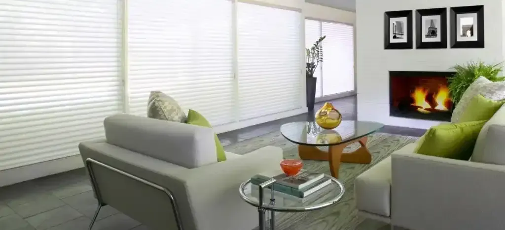 A modern living room with white couches, a fireplace, and a glass coffee table.