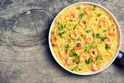 Pasta with shrimps & tomato on wooden background