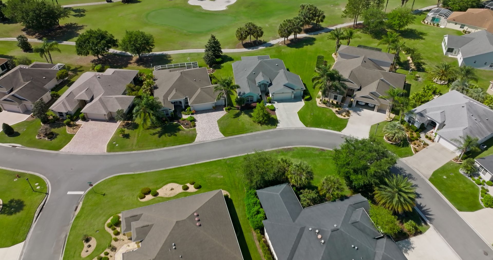 Aerial view of retirement villages with neat lawns, driveways, and golf course in background. Aerial view of retirement villages with neat lawns, driveways, and golf course in background.