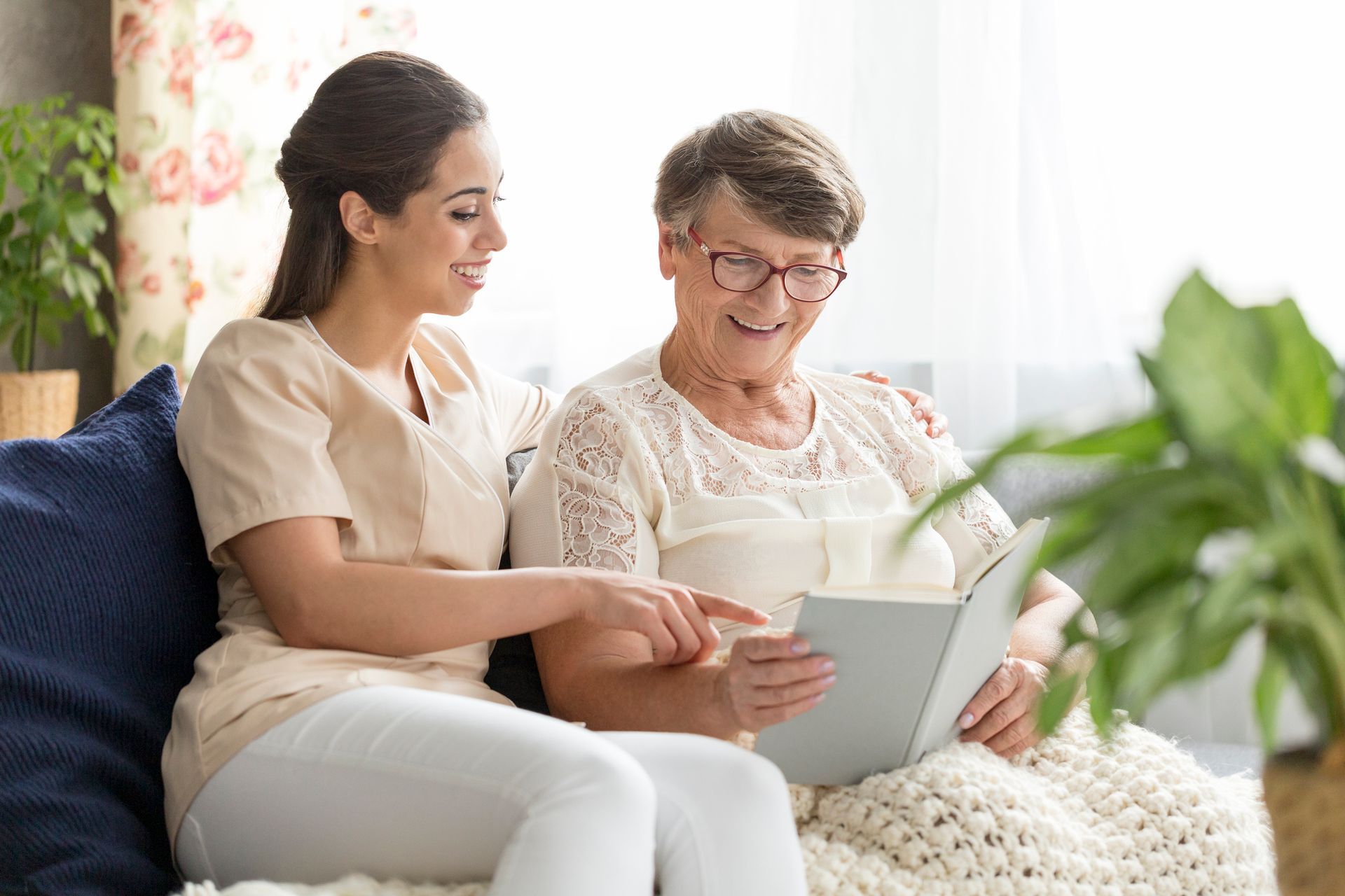 Granddaughter and happy senior woman watching photobook. Granddaughter and happy senior woman watching photobook.