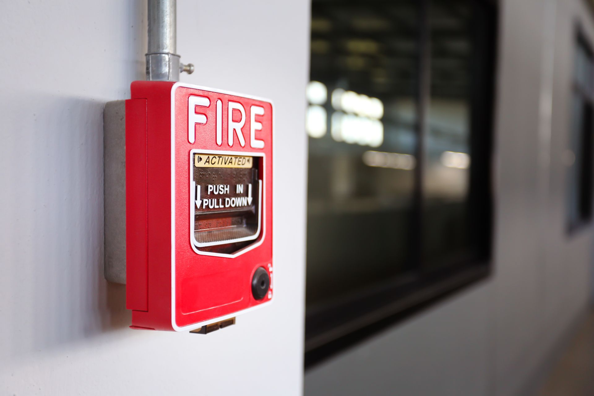 A fire alarm switch on the wall in the factory, showcasing fire protection services. A fire alarm switch on the wall in the factory, showcasing fire protection services.