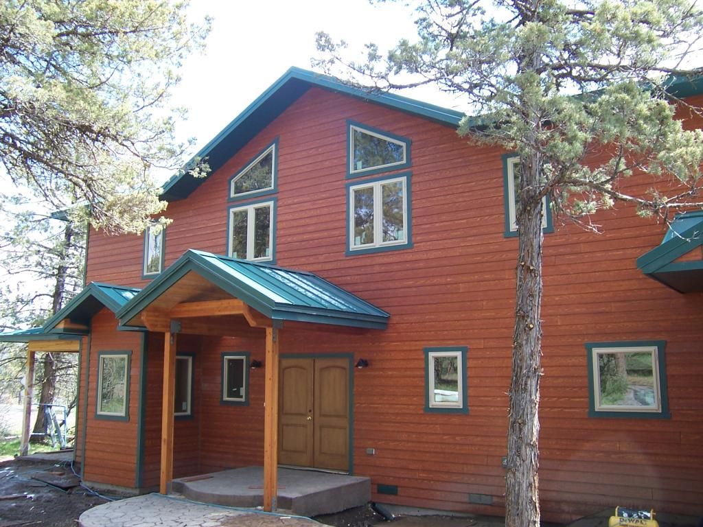 A large wooden house with a green roof