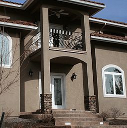 A large house with a balcony and stairs leading up to it