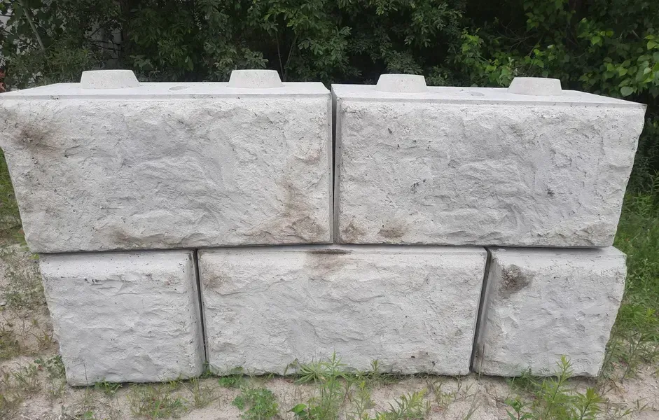 Blocs de soutènement en béton gris empilés à l'extérieur.
