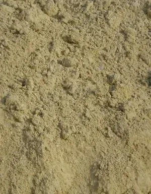 Gros plan sur un tas de sable beige clair.