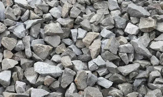 Gros plan sur du gravier gris. Roches rugueuses et anguleuses de tailles et de nuances de gris variées.