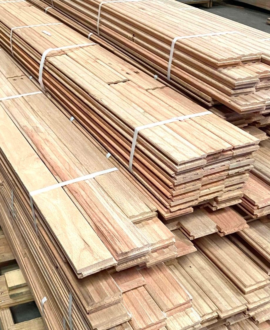 Bundles of raw, light-colored wooden planks stacked neatly on wooden pallets.