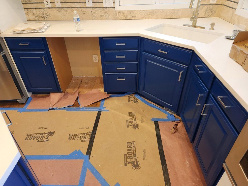 A kitchen with blue cabinets and white counter tops