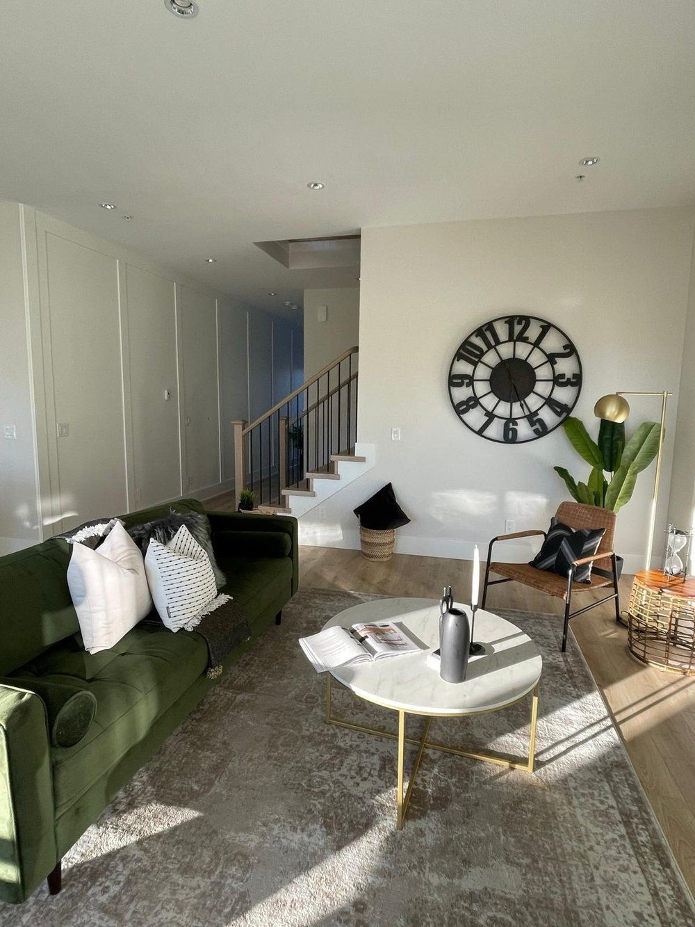 There is a large clock on the wall in the living room.