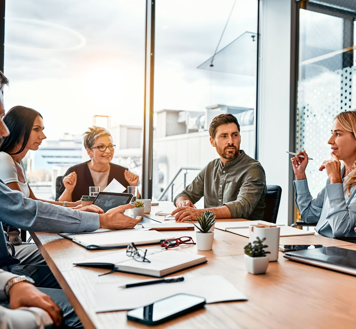 A group of people are sitting around a table having a meeting.